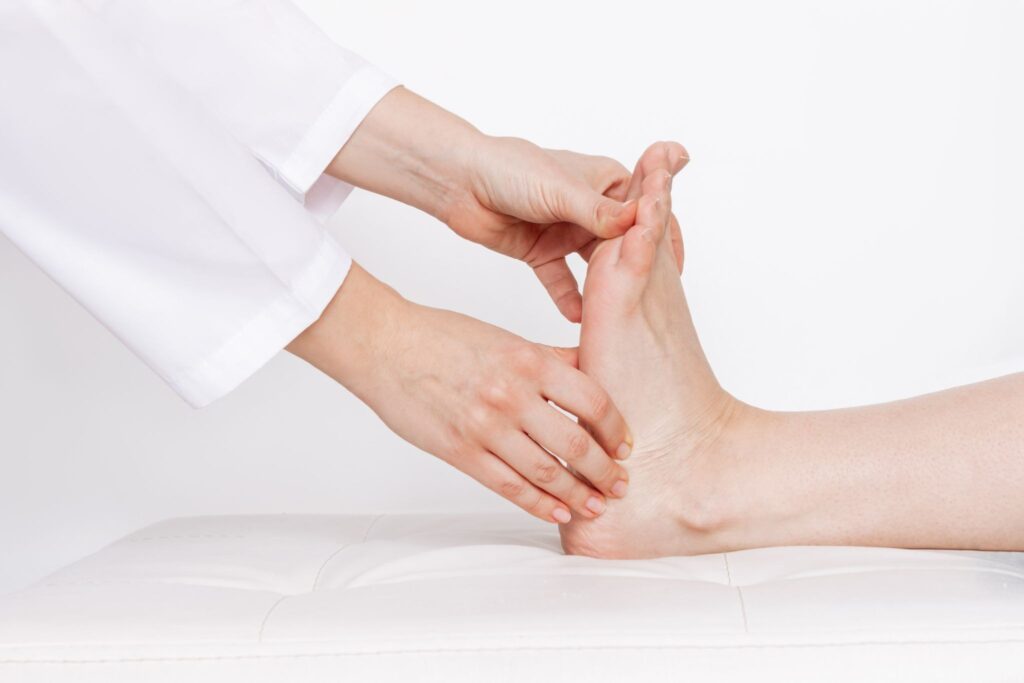 Orthopaedic specialist examining a patient's foot to diagnose flat feet (pes planus).